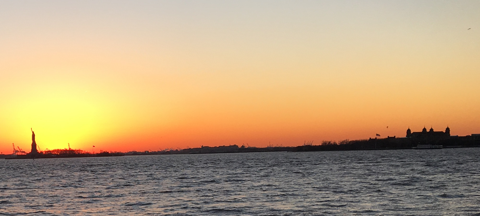 Statue of Liberty and Ellis Island at sunset